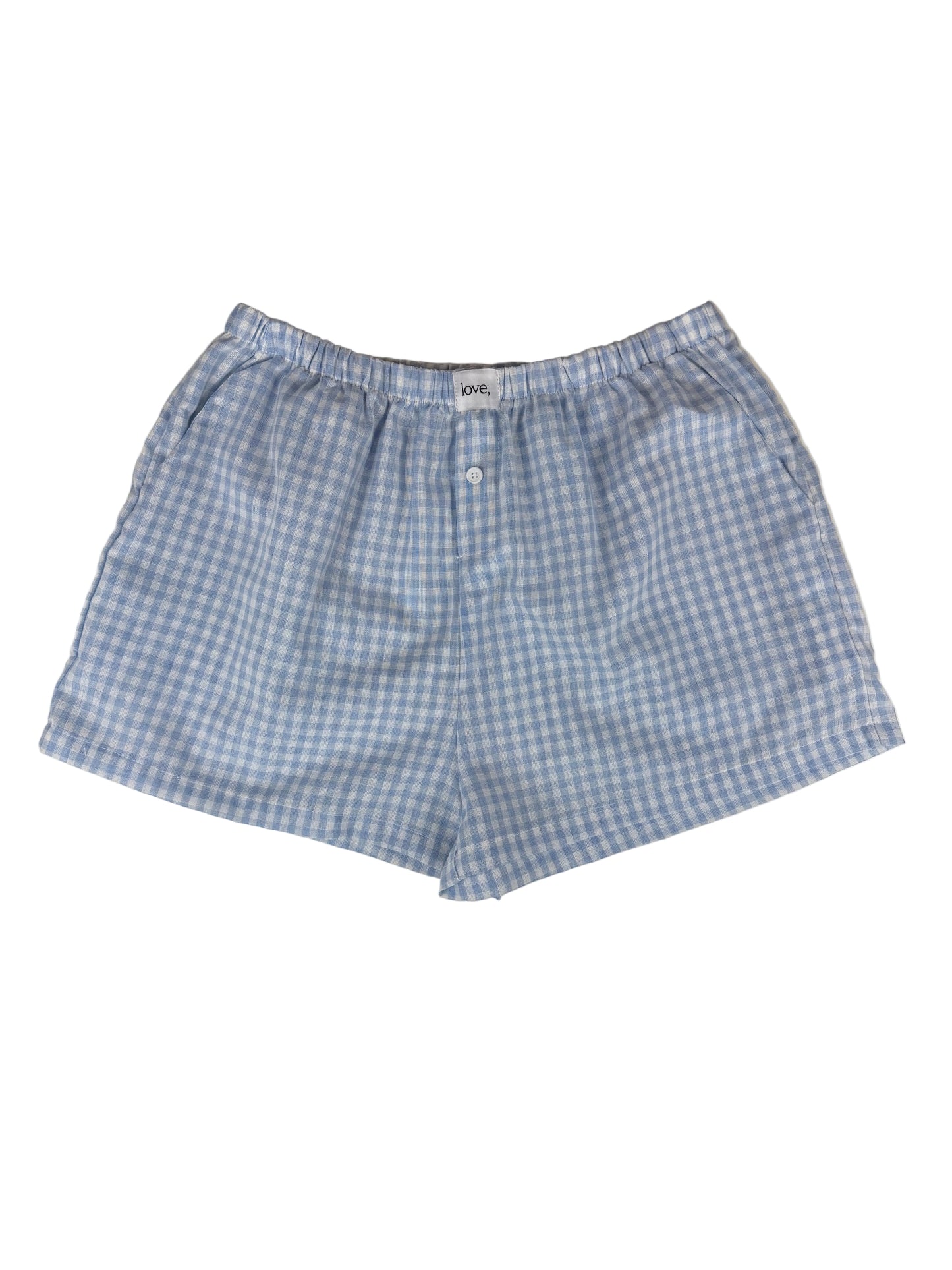 Blue and white gingham boxer shorts on a light gray surface.