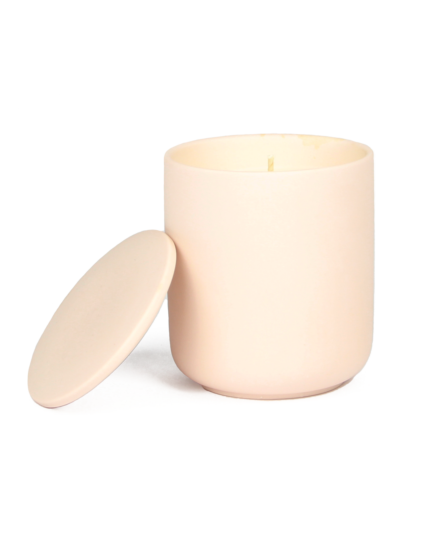 Pink colored candle with lid on a white background