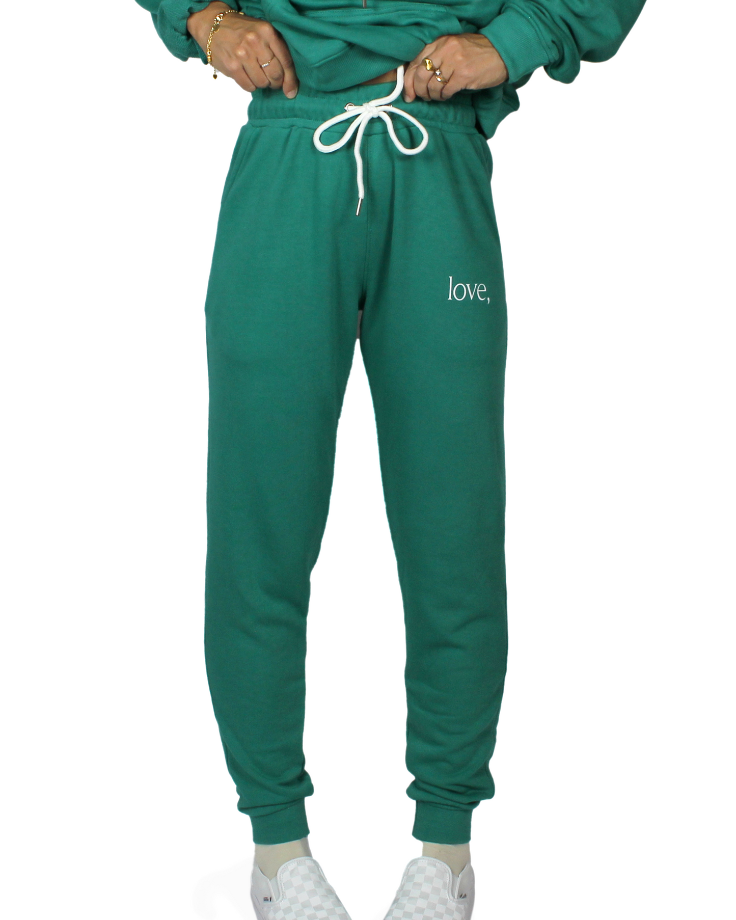 Green sweatpants with 'love,' logo on a white background
