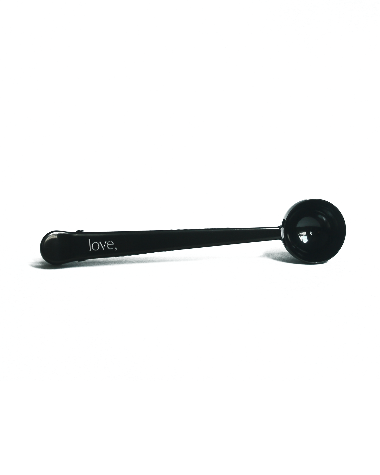 Black coffee scoop with 'love,' inscription on a white background