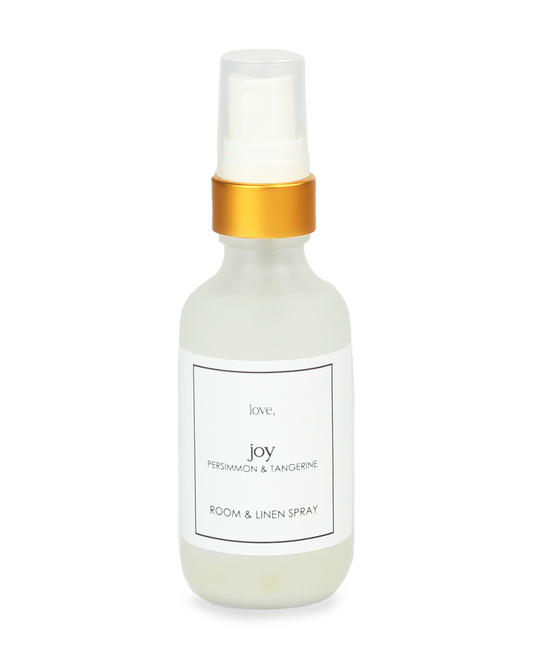 Room and linen spray bottle with gold cap on a white background