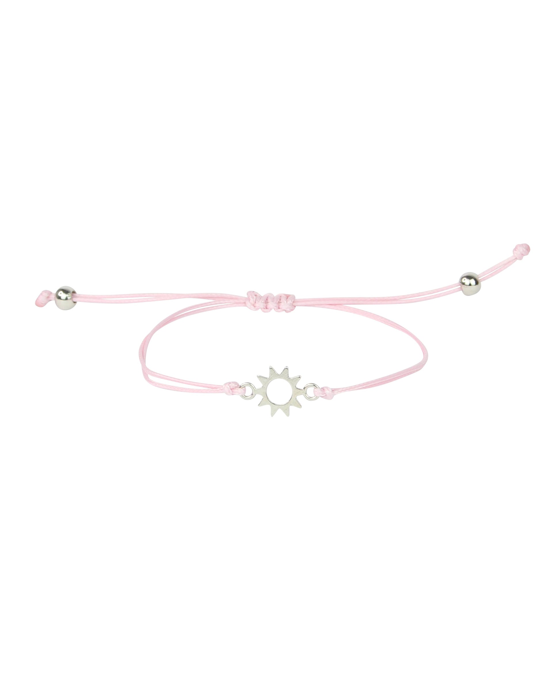 Pink bracelet with a silver sun charm on a white background