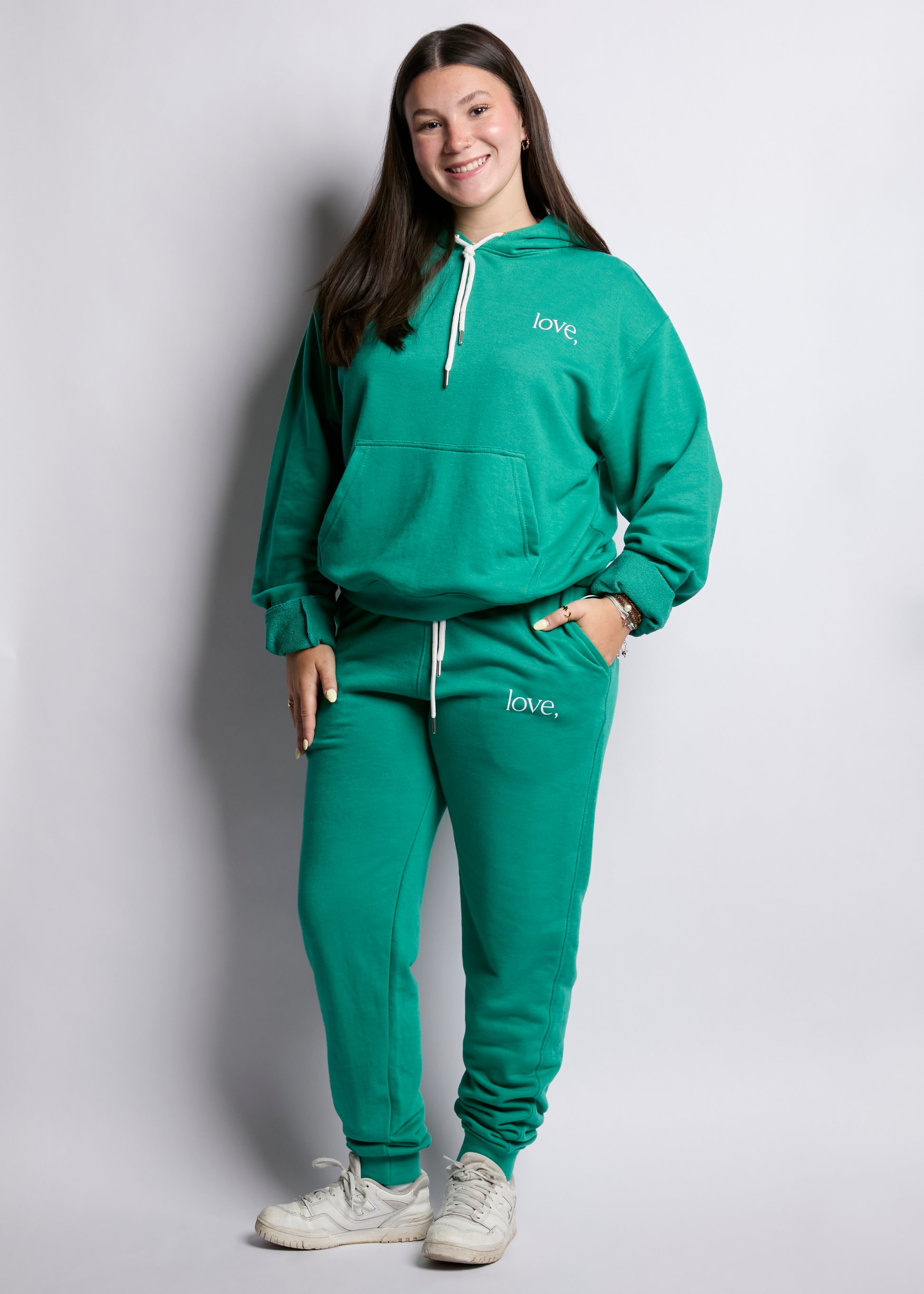 Person wearing a green tracksuit with 'love' branding on a plain background