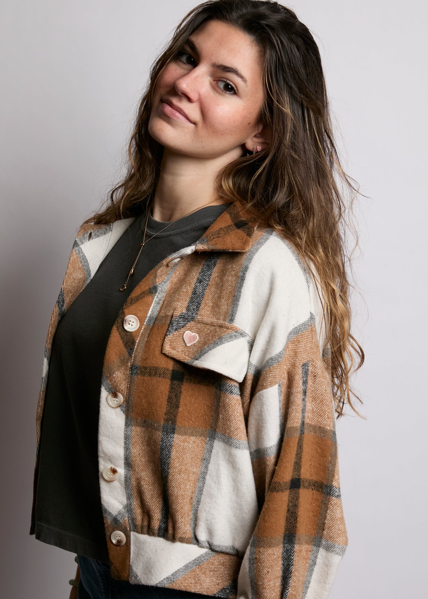 Woman wearing a plaid shirt with a neutral background