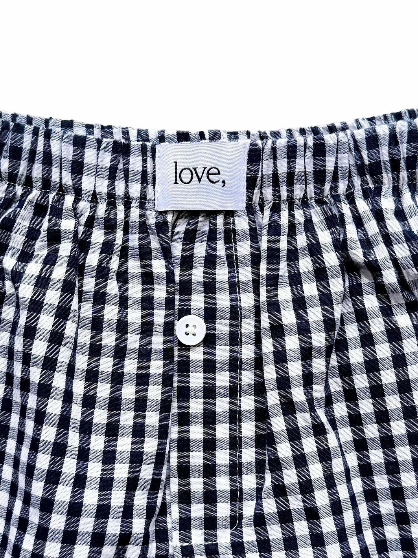 Black and white checkered boxer shorts with a button and 'love' label on a white background