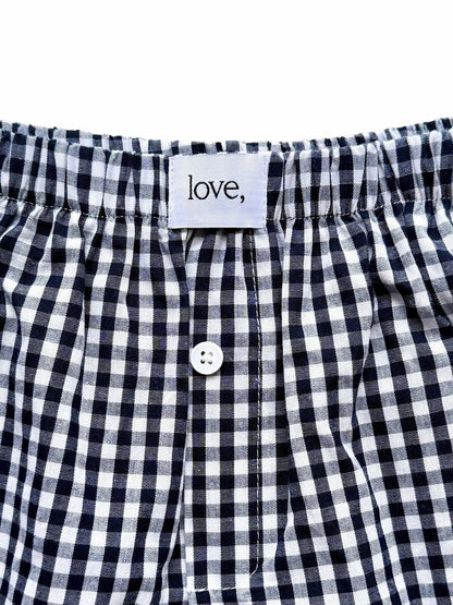 Black and white checkered boxer shorts with a button and 'love' label on a white background