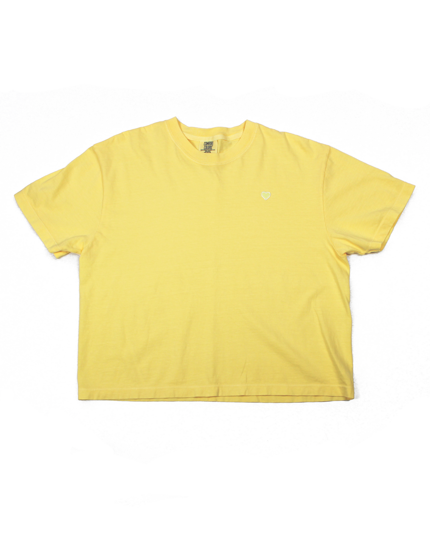 Yellow tee with a heart patch on a white background.
