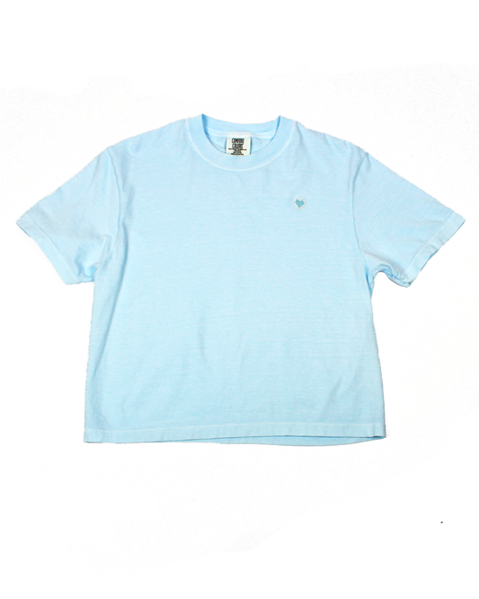Light blue tee with heart patch on a white background