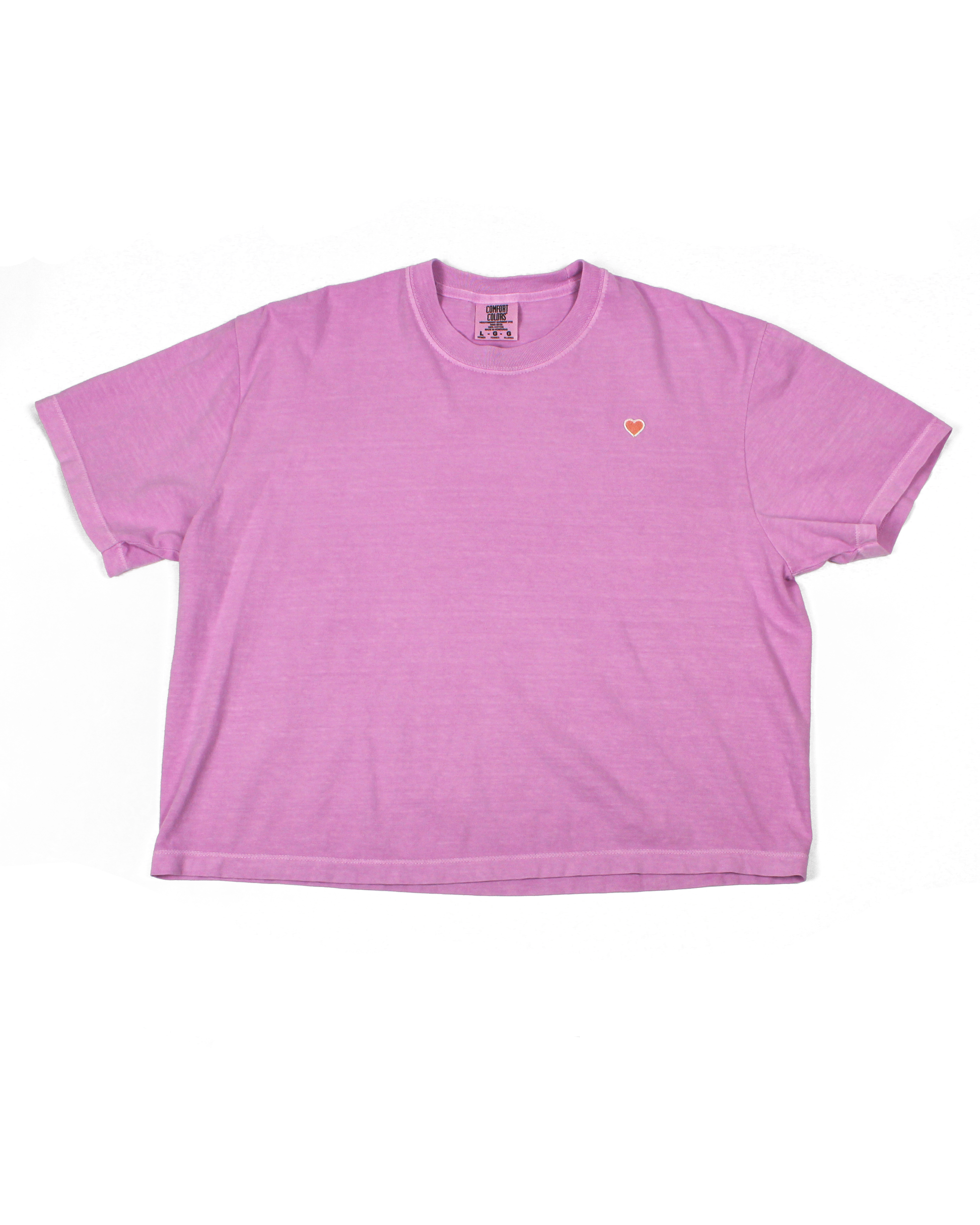 Pink tee with heart patch on a white background