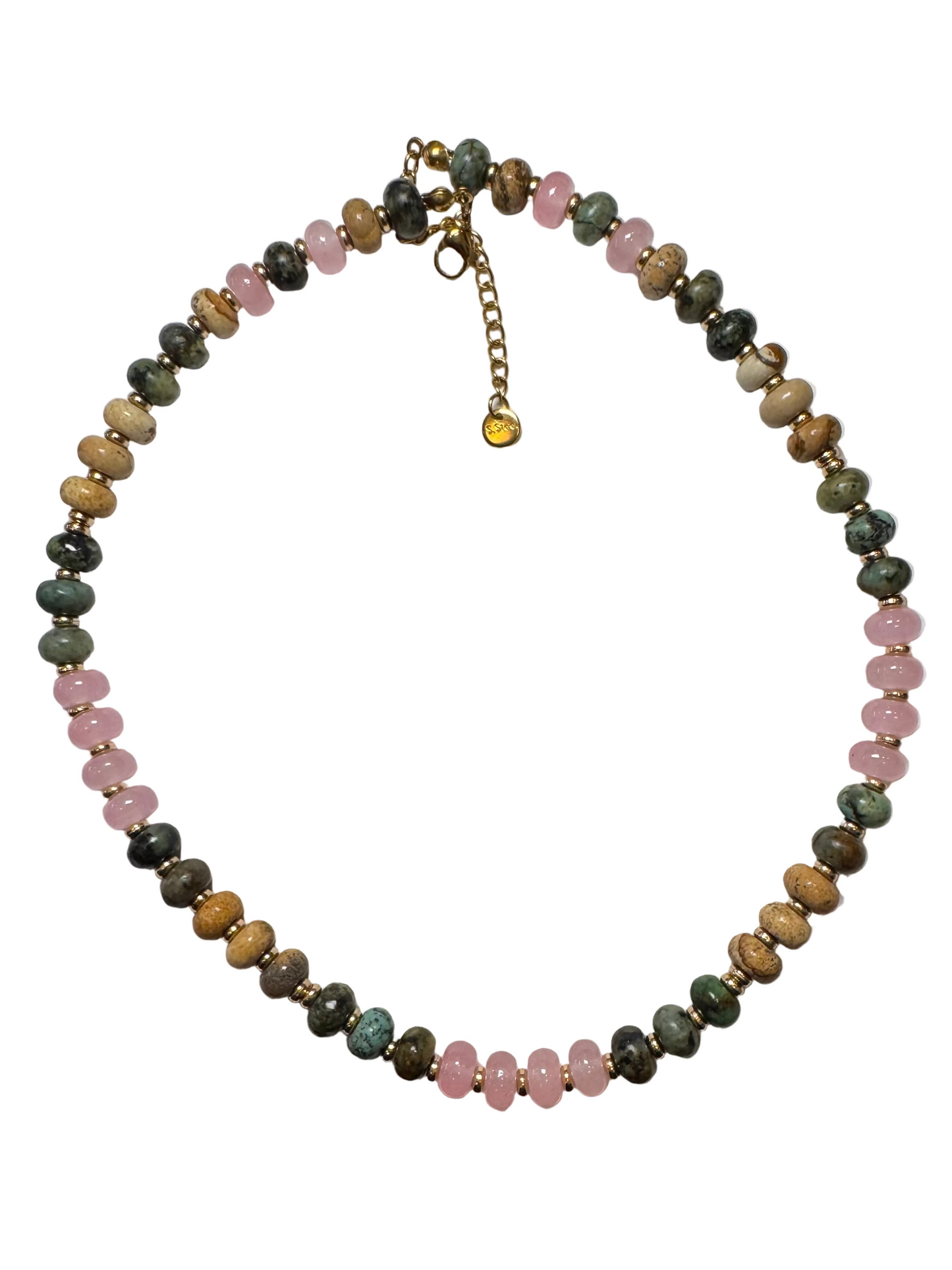 A beaded necklace made of round stone beads in pink, green, brown, and gray, with small gold spacer beads and a gold clasp featuring an extension chain and heart charm, laid flat on a white sheet of paper.