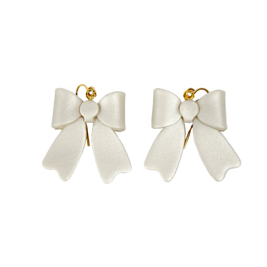 White bow-shaped earrings on a white background