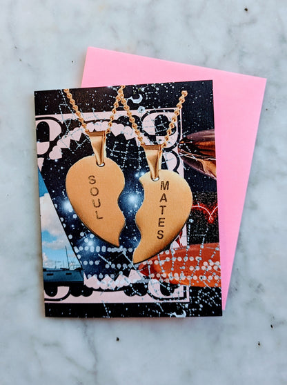 A greeting card with a design that includes two heart-shaped pendants with the words 'SOUL' and 'MATES' respectively, placed on a background with a celestial theme.