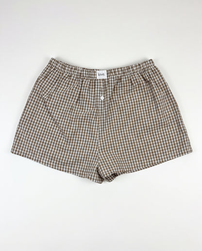 Brown and beige gingham check boxer shorts with an elastic waistband and front button closure, laid flat on a white background.
