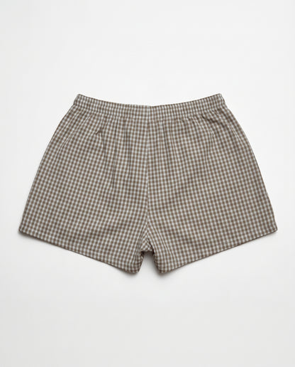 A pair of men's boxer shorts featuring a brown and beige gingham checkered pattern, laid flat against a light gray background.
