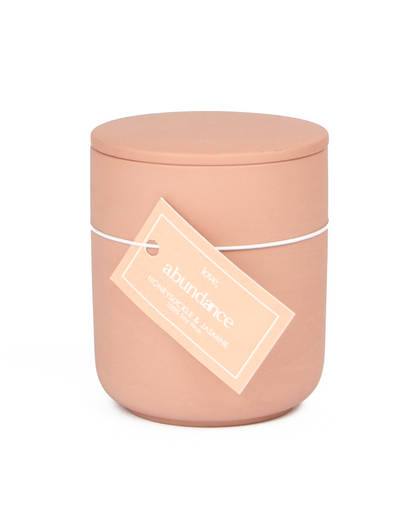 Pink candle with a label on a white background