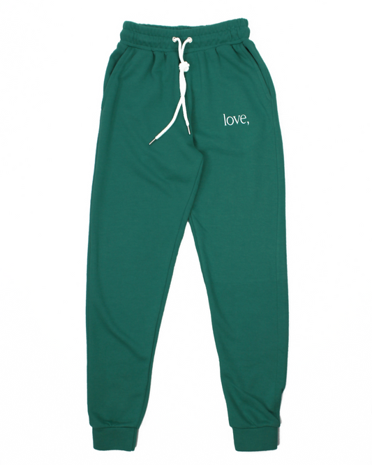 Green sweatpants with 'love,' text on a white background