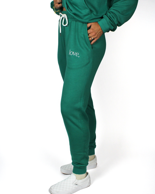 Person wearing a green tracksuit with 'love,' text on a white background