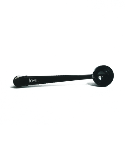 Black coffee scoop with 'love,' inscription on a white background