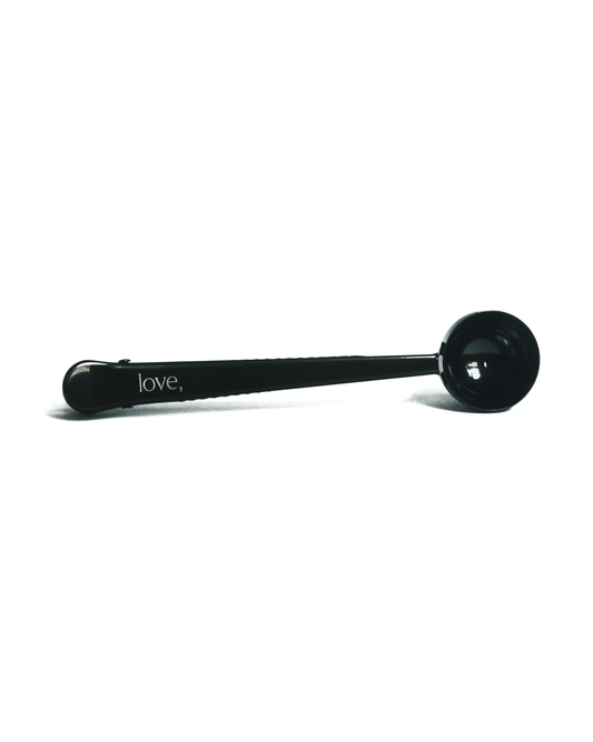 Black coffee scoop with 'love,' inscription on a white background