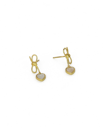Gold earrings with heart-shaped charms on a white background