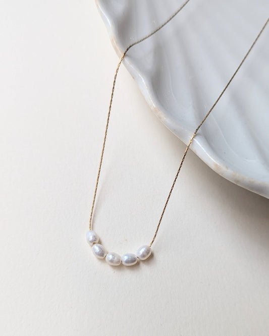Pearl necklace on a light surface with a subtle background
