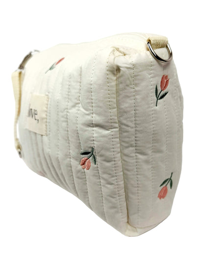 White quilted bag with floral embroidery on a white background