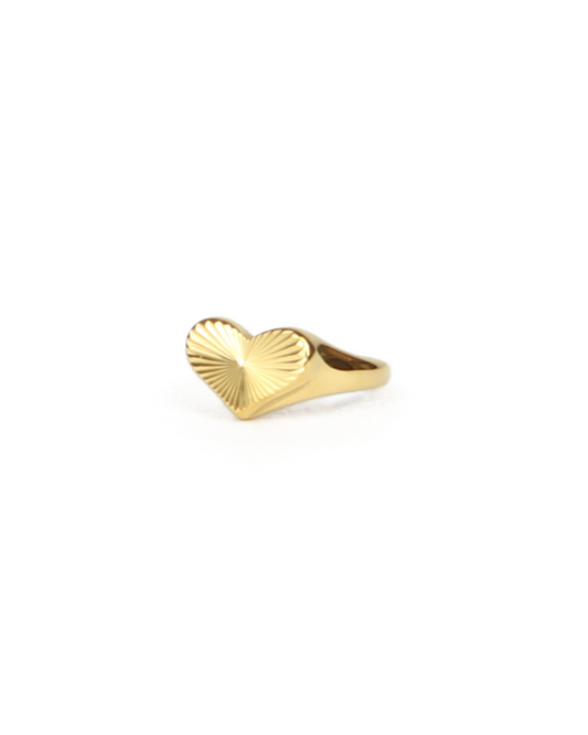 Gold heart-shaped ring on a white background