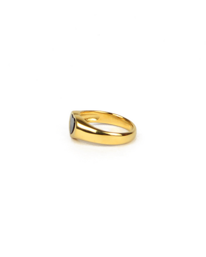 Gold ring with black enamel on a white background
