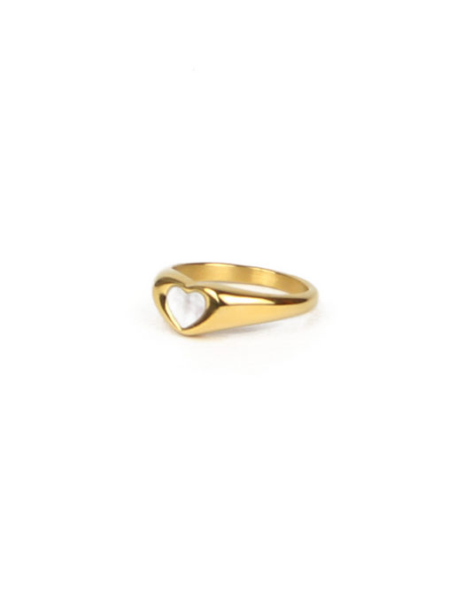 Gold ring with a heart design on a white background