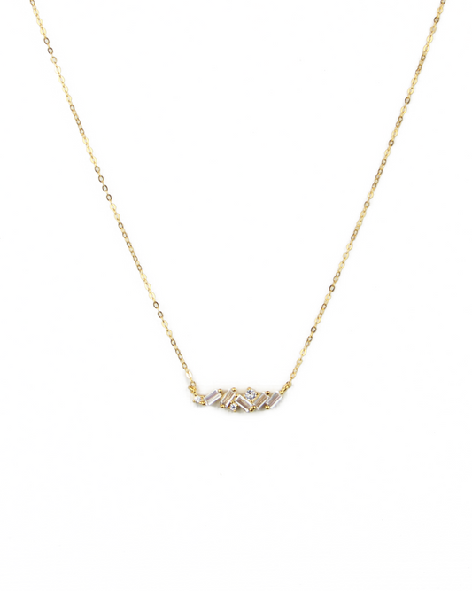 Gold necklace with a small pendant on a white background
