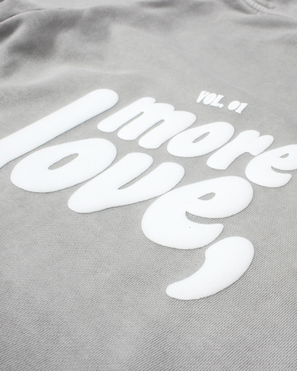 close up of grey hoodie on a white background with text more love,