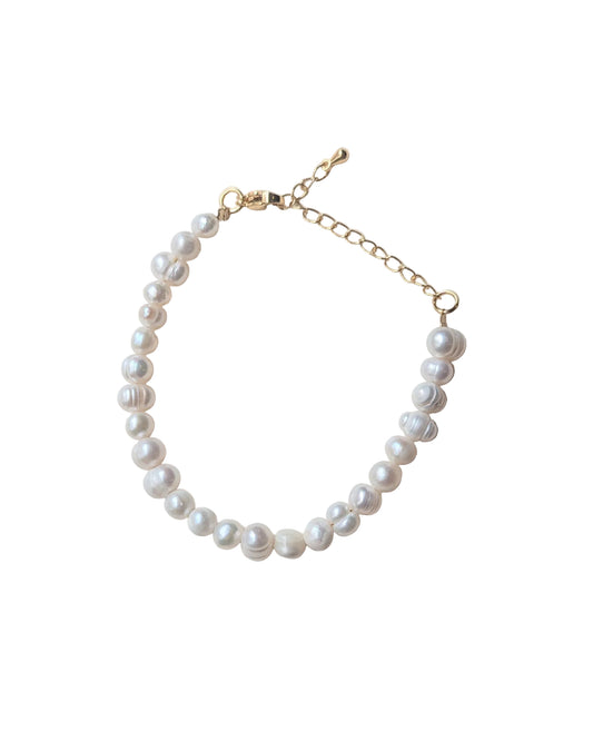 Pearl bracelet with gold clasp on a white background