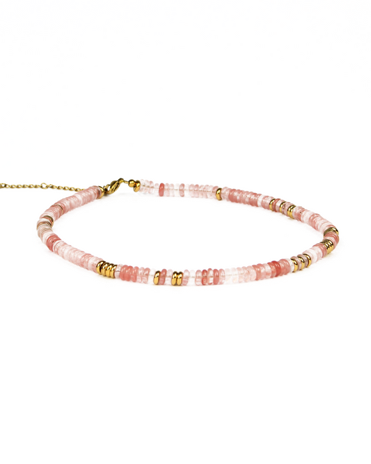 Beaded necklace with pink and gold accents on a white background